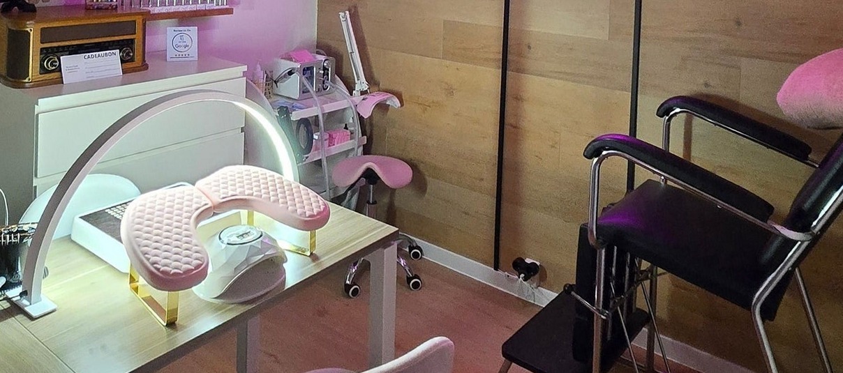 Werkplek met nagellamp, roze handsteun en de pedicurestoel