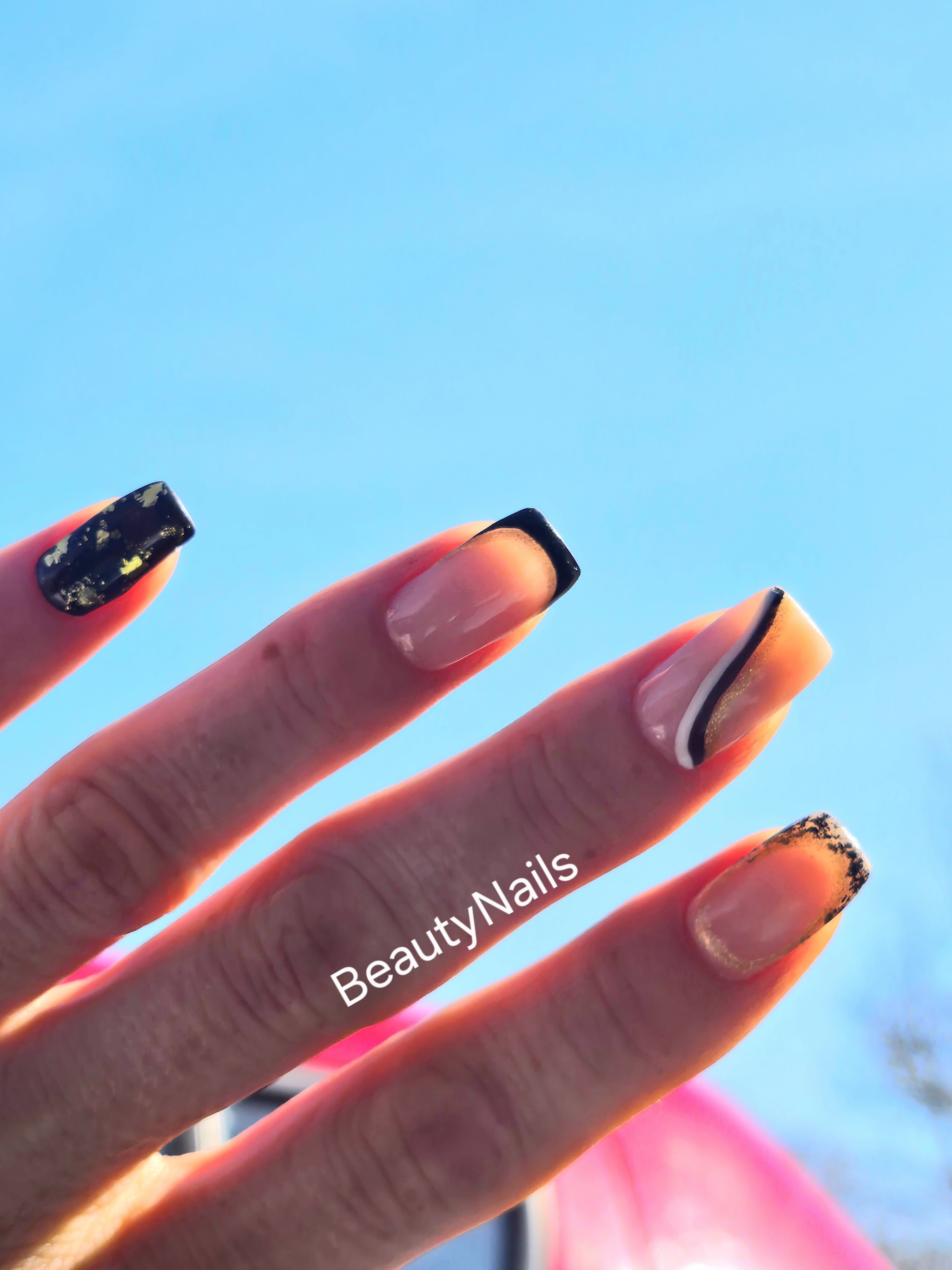 Nude nagels met zwarte French-randjes en bladgoud