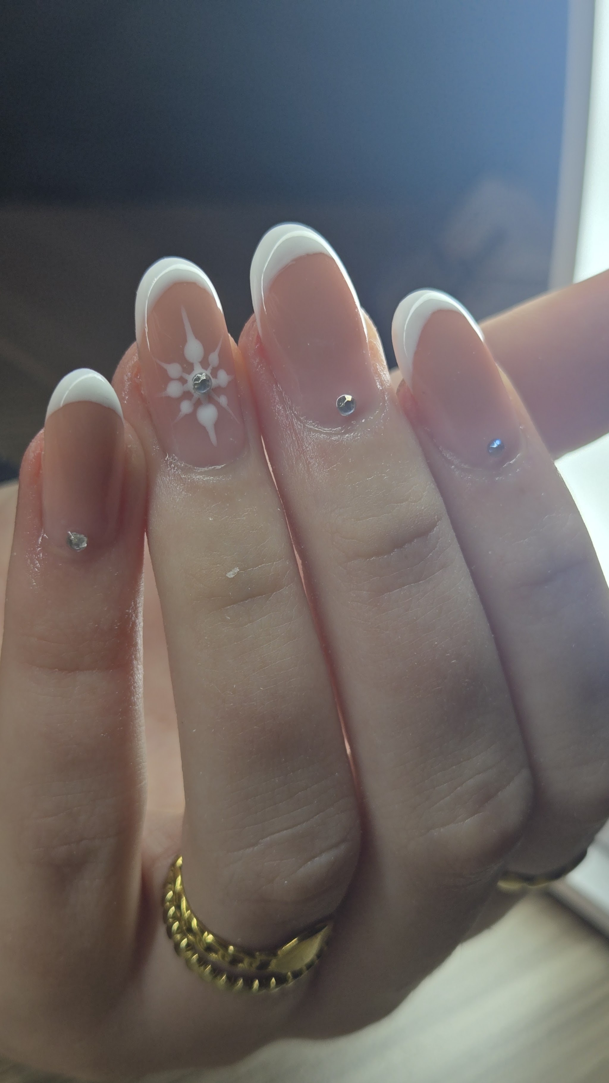 Witte French-nagels in amandelvorm met een bloemetje